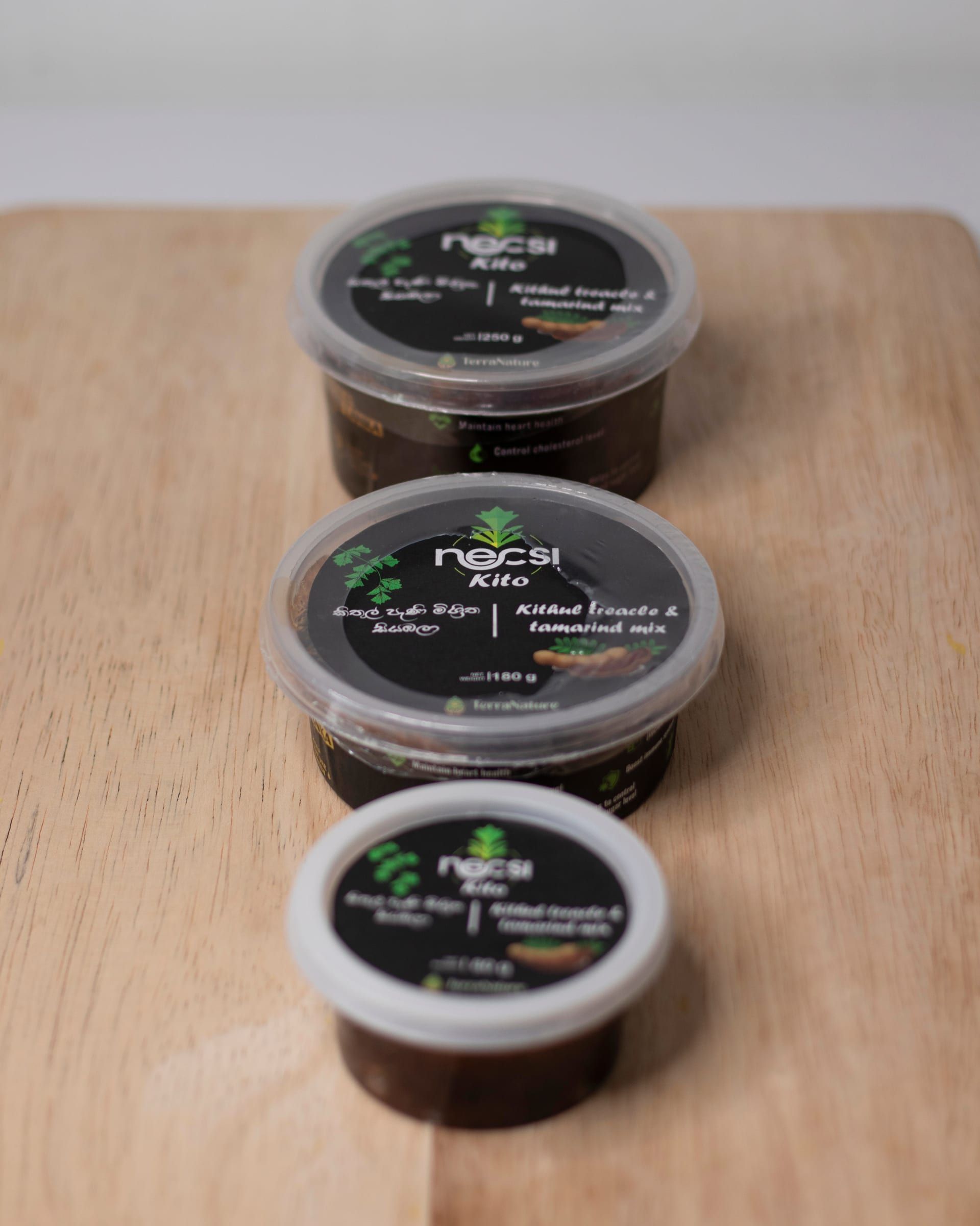 Necsi Kito in all three tub sizes lined up on a wooden board, 250 g at the back, then 180 g and 80 g in front